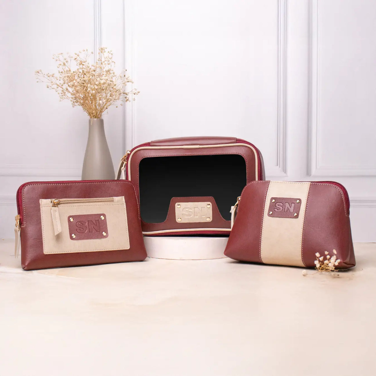 Personalised vanity kit set with maroon makeup pouches displayed on a tabletop