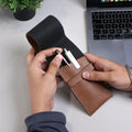 Hand holding brown leather pen pouch with stylus