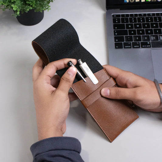 Hand holding brown leather pen pouch with stylus