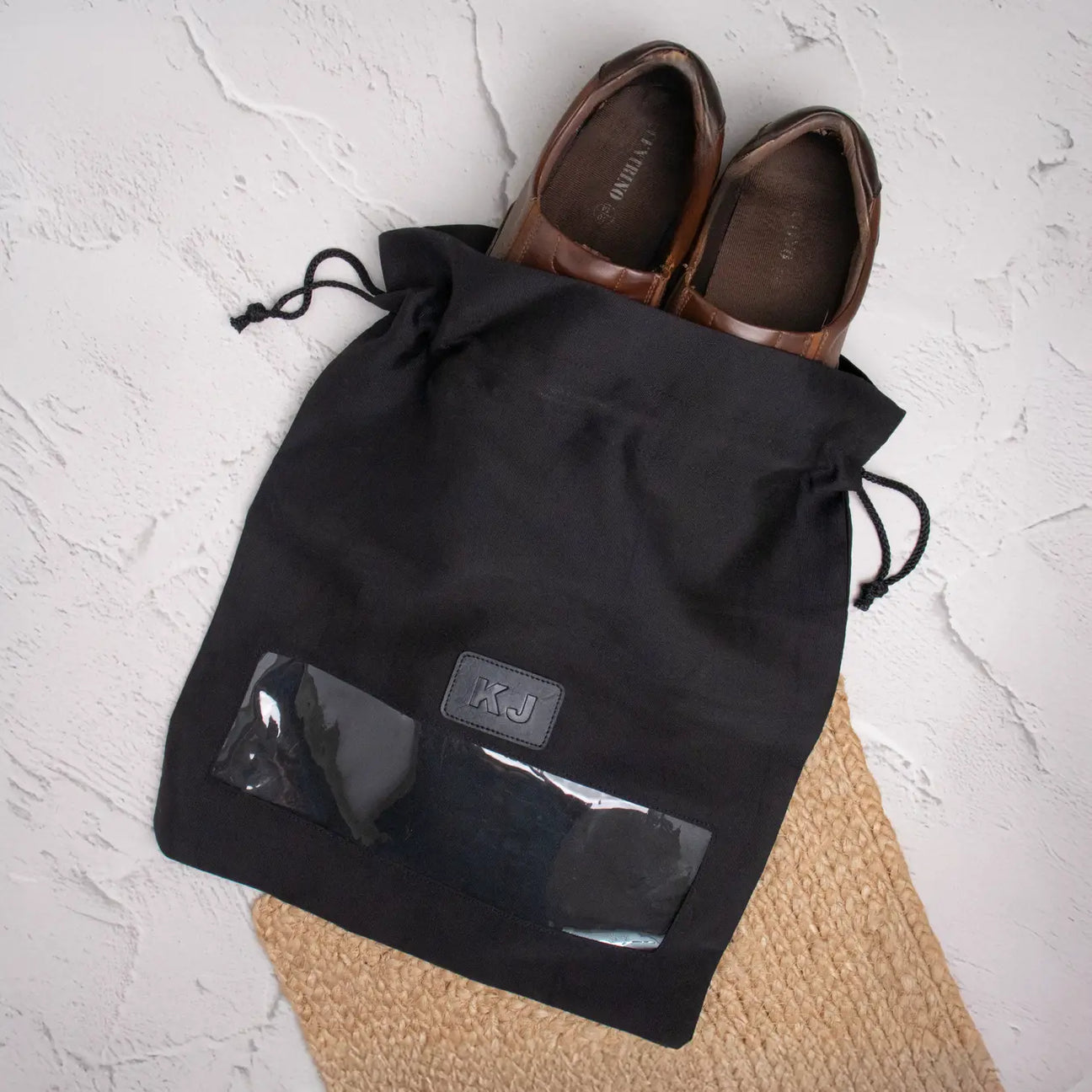 Black drawstring shoe bag with shoes inside