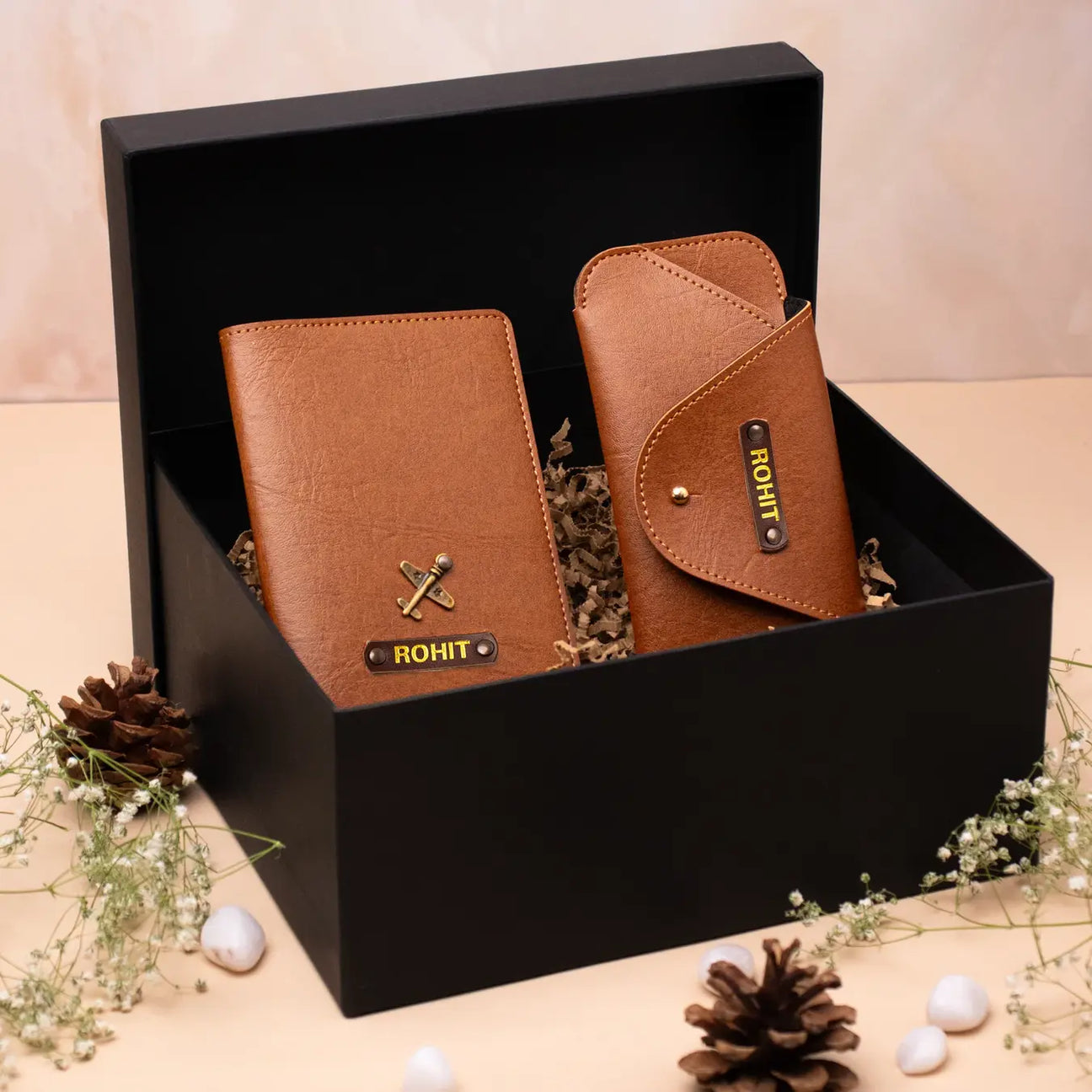 Brown leather wallet and sunglass case displayed in a black gift box