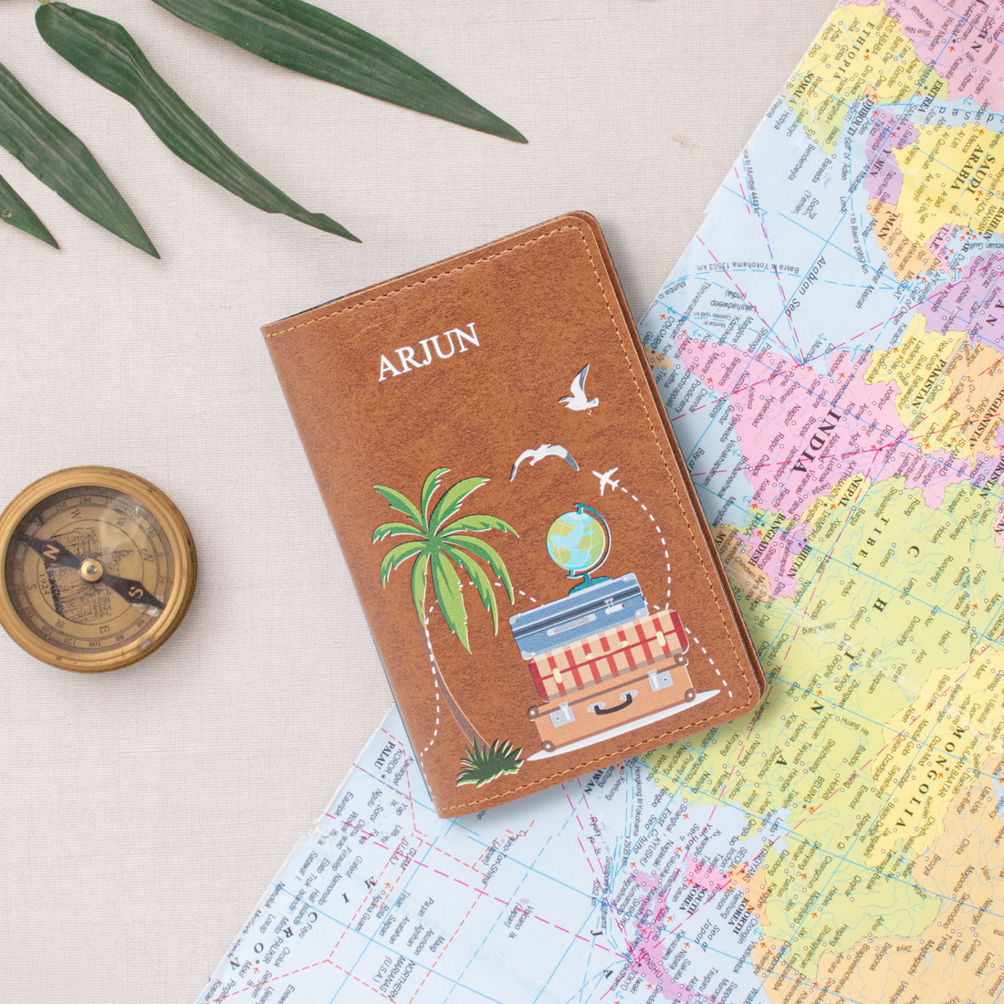 Tan personalized passport cover on a world map