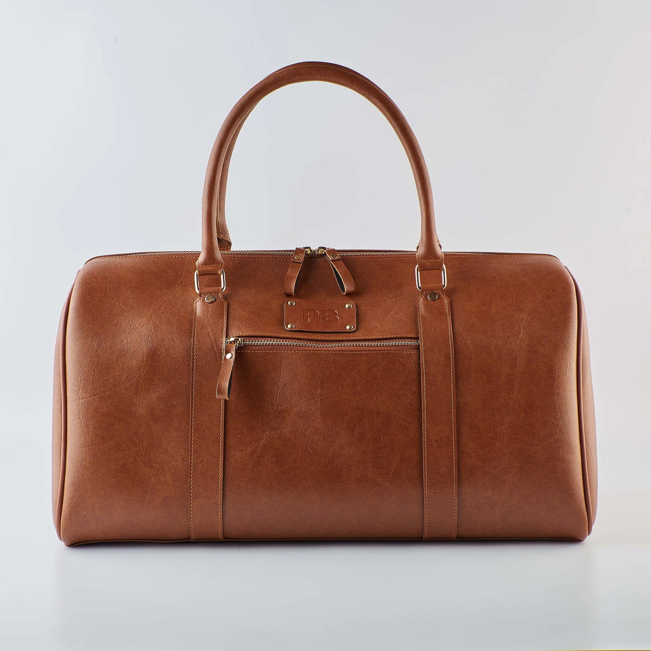 Tan duffel bag with handles and front zipper