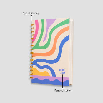 Colorful wavy notebook and coffee on a wooden table.