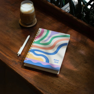 Colorful wavy notebook and coffee on a wooden table.