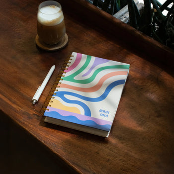 Colorful wavy notebook and coffee on a wooden table.