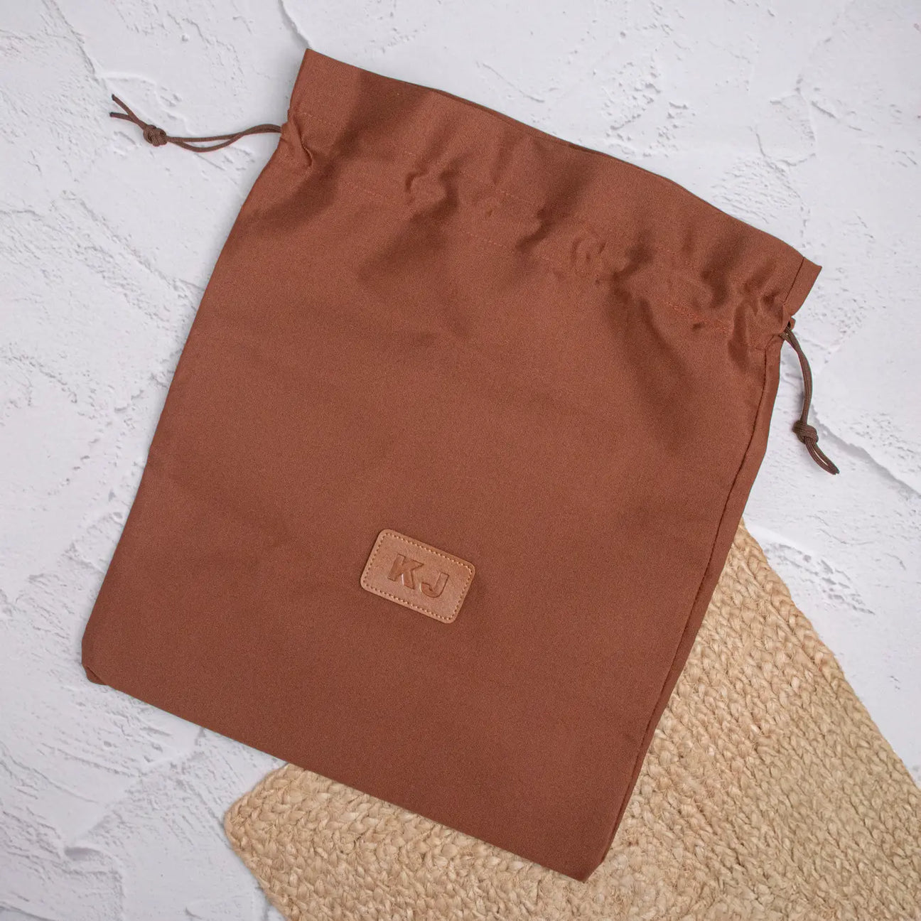 Tan shoe bag on textured background