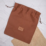 Tan shoe bag on textured background