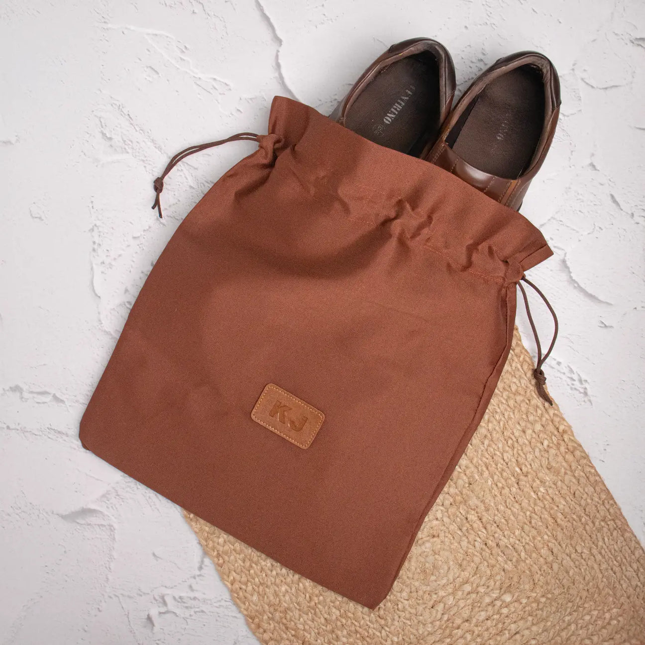 Tan shoe bag on textured background
