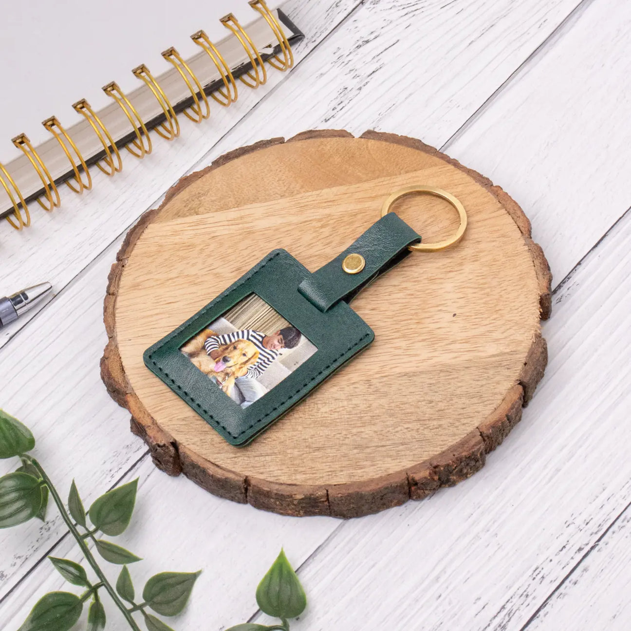 Personalised green leather photo keyring on wooden surface